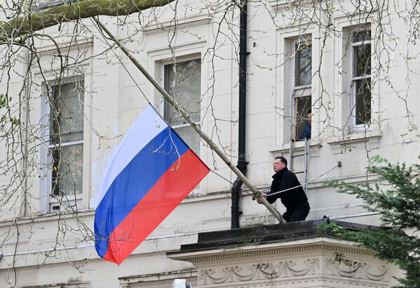 شخص ينكّس العلم الروسي خارج السفارة الروسية في لندن، في 23 مارس 2024، بعد يوم من هجوم مسلح على قاعة &quot;كروكوس سيتي&quot; في ضواحي موسكو. - سبوتنيك عربي