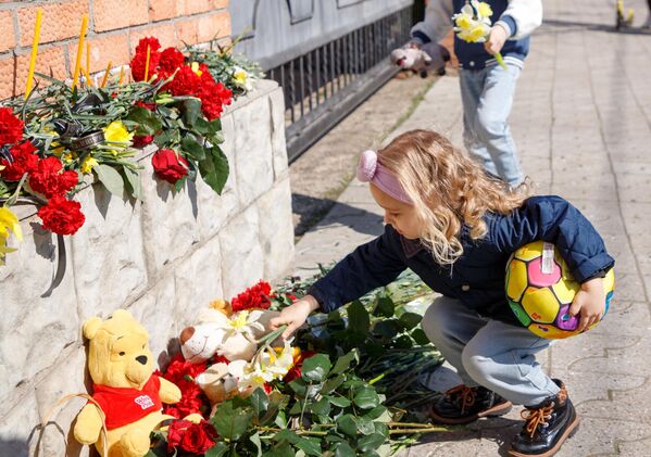 طفلة تضع الزهور على نصب تذكاري مؤقت بالقرب من القنصلية الروسية في تيراسبول، ملدوفا، خلال فعالية لإحياء ذكرى ضحايا الهجوم الإرهابي في قاعة &quot;كروكوس سيتي&quot; بضواحي موسكو. - سبوتنيك عربي