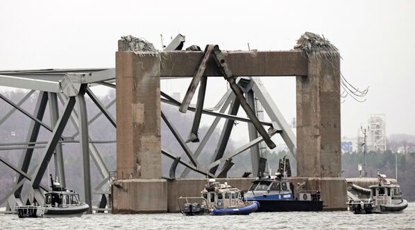 تعمل قوارب الغوص التابعة للشرطة حول جزء من هيكل جسر &quot;فرانسيس سكوت كي&quot; بعد اصطدام السفينة بالجسر في بالتيمور، في ولاية ماريلاند، 27 مارس 2024 - سبوتنيك عربي