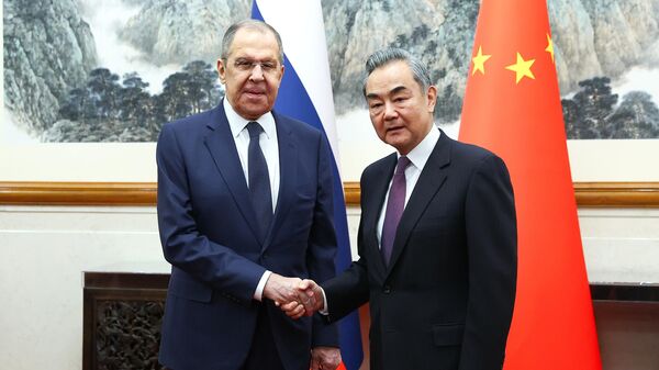 وزير الخارجية الروسي سيرغي لافروف (يسار) وزير الخارجية الصيني وانغ يي خلال اجتماع في بكين.  - سبوتنيك عربي