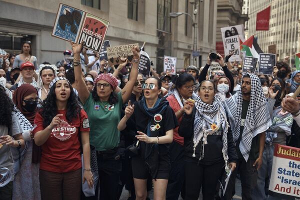 المتظاهرون يرددون شعارات خلال مظاهرة مؤيدة للفلسطينيين تطالب بالحصار الاقتصادي ووقف إطلاق النار في الصراع الإسرائيلي الفلسطيني خارج بورصة نيويورك، يوم الاثنين 15 أبريل 2024 في نيويورك. - سبوتنيك عربي