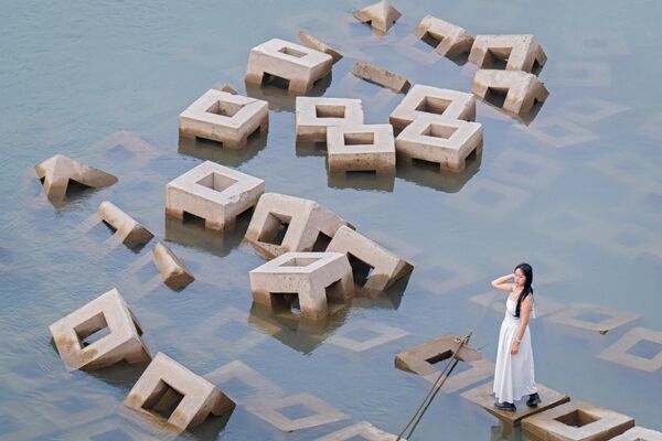 امرأة تقف على حاجز كسر الأمواج، في تشونغتشينغ، الصين. - سبوتنيك عربي