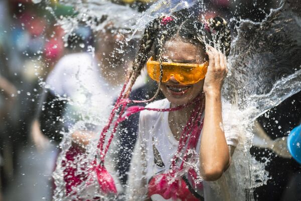 ردة فعل امرأة عندما تم إلقاء دلو من الماء عليها، خلال مهرجان المياه &quot;سونغكران&quot;، تايلاند. - سبوتنيك عربي