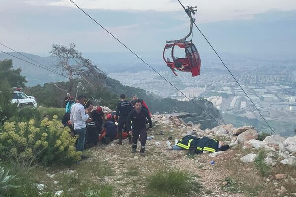 أعضاء فريق للإنقاذ والطوارئ يعملون مع ركاب التلفريك خارج أنطاليا، جنوب تركيا، بعد تعرضهم لحادث. - سبوتنيك عربي
