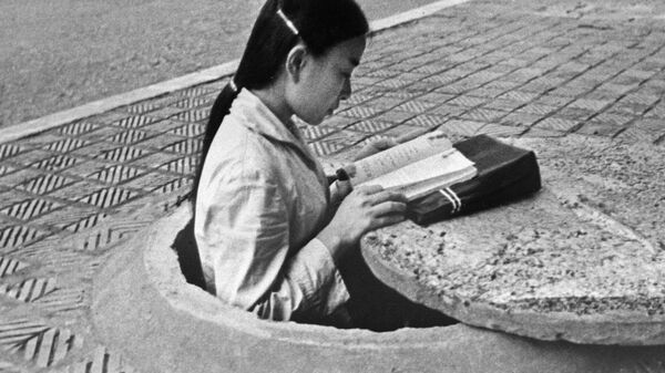 Жительница Ханоя читает книгу в перерыве между налётами - سبوتنيك عربي