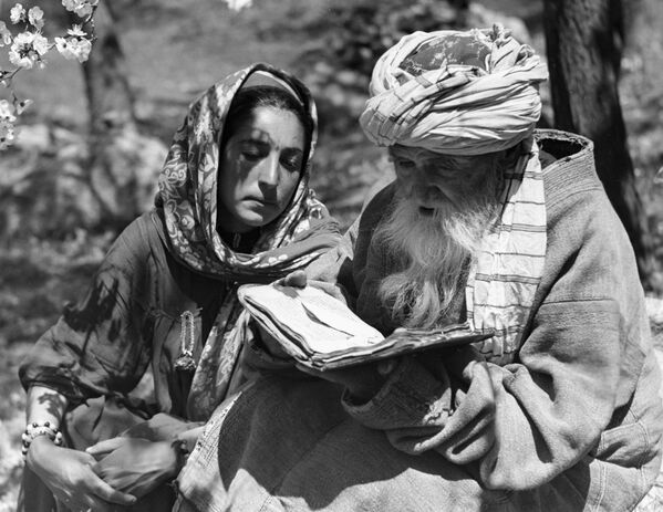 رجل وفتاة يقرآن كتابًا في حديقة، في طاجيكستان - سبوتنيك عربي