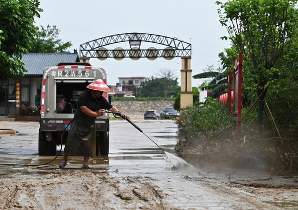 عامل يزيل الطين من الطريق بعد أن غمرت الأمطار الغزيرة المنطقة في تشينغيوان في مقاطعة قوانغدونغ الشمالية، في 24 أبريل 2024. - سبوتنيك عربي