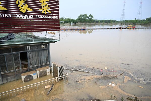 منظر عام يظهر مطعمًا متضررًا بجوار بركة صغيرة بعد أن غمرت الأمطار الغزيرة المنطقة في تشينغيوان بمقاطعة قوانغدونغ الشمالية، في 24 أبريل 2024. - سبوتنيك عربي