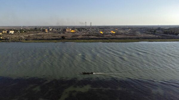 عراقي يقود قاربه في نهر شط العرب بجوار حقل نهر بن عمر النفطي بالقرب من مدينة البصرة الساحلية جنوب العراق، 4 نيسام/ أبريل 2023 - سبوتنيك عربي