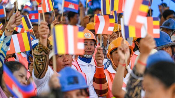 Рабочие держат флаги во время марша по улице в честь Международного дня труда в Пномпене, Камбоджа - سبوتنيك عربي
