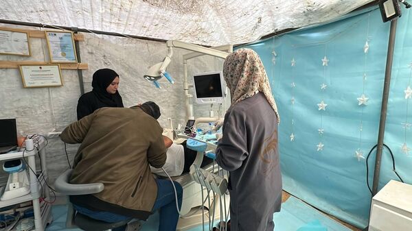 خيمة الأسنان  طبيب يحوّل خيمة النزوح إلى عيادة أسنان لعلاج المرضى في مخيم النصيرات وسط قطاع غزة  - سبوتنيك عربي
