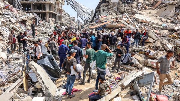 Люди собираются у разрушенного здания на месте сброса гуманитарной помощи на севере сектора Газ - سبوتنيك عربي