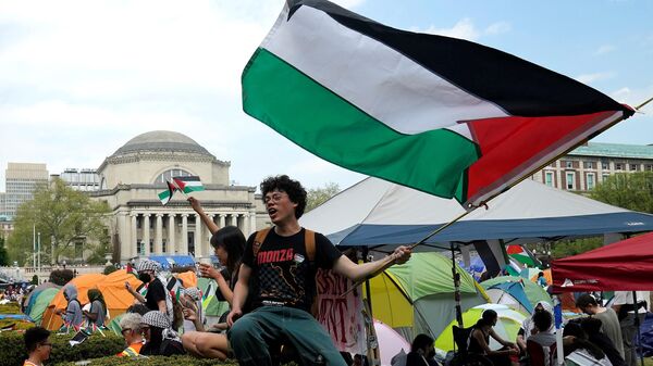 Протестующие размахивают палестинскими флагами на Западной лужайке Колумбийского университета в Нью-Йорке - سبوتنيك عربي
