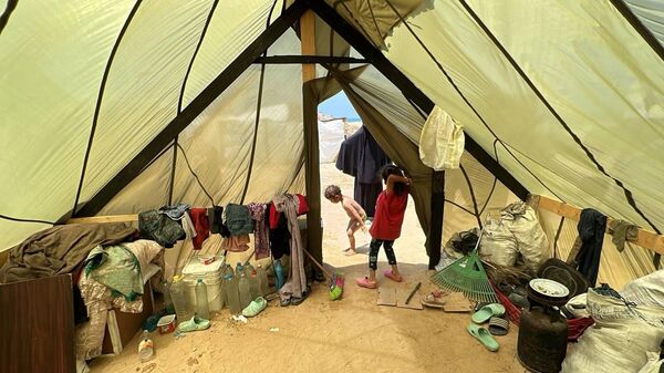 فلسطيني يشيد خيمة لعائلته من مظلات الإنزال الجوي في قطاع غزة - سبوتنيك عربي