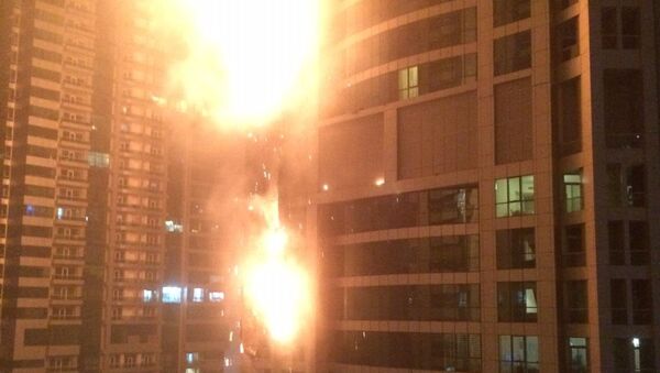 This photo provided by Rhea Saran shows flames coming from a high rise tower in Dubai's marina district Saturday, Feb. 21, 2015. - سبوتنيك عربي