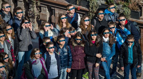 أطفال يشاهدون كسوف الشمس عير نظارات واقية في ميونيخ - سبوتنيك عربي