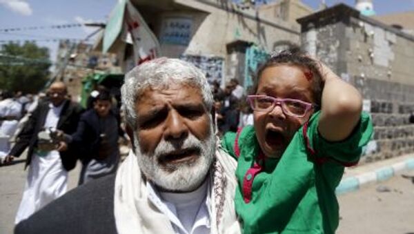 رجل مسن يهرب بطفلة من مكان الانفجار في اليمن اليوم الجمعة 20 مارس/ آذار 2015. - سبوتنيك عربي