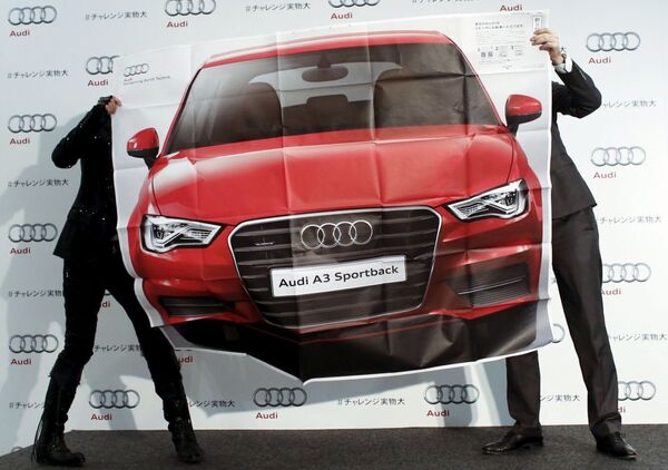 الرجال يحملون لافتة إعلانية للسيارة أودي A3 خلال المعرض في صالة عرض لصناعة السيارات الألمانية في طوكيو - سبوتنيك عربي