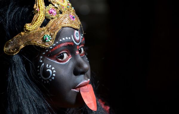 فتاة هندية في زي الألهة كالي تتدرب قبل المشاركة في احتفال ديني في مهرجان غادجا في كلكتا - سبوتنيك عربي