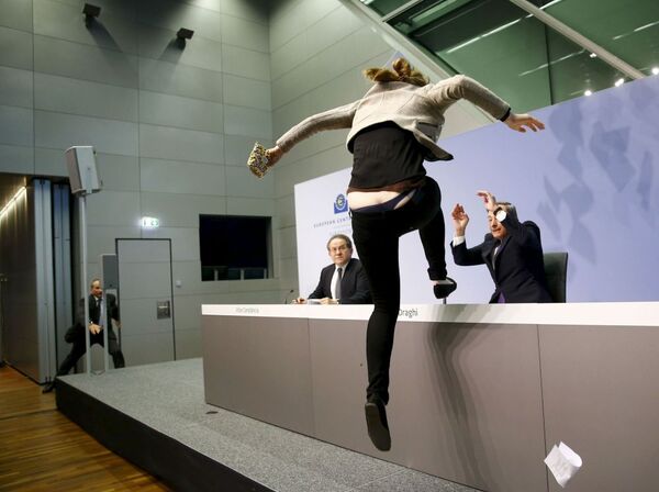 ناشطة تقفز على طاولة رئيس البنك المركزي الأوروبي ماريو دراغي في فرانكفورت - سبوتنيك عربي