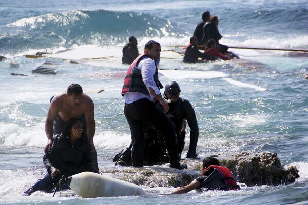 أفراد من حرس السواحل اليوناني يحاولون إنقاذ  المهاجرين الذين حاولوا  الإبحار إلى اليونان، بالقرب من  جزيرة رودس - سبوتنيك عربي