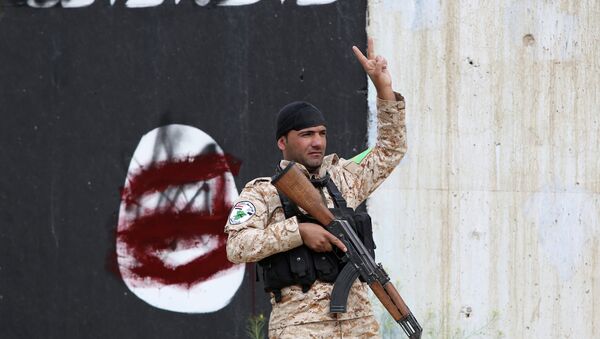 فرد من قوات الأمن العراقية يرفع إشارة النصر في تكريت - سبوتنيك عربي