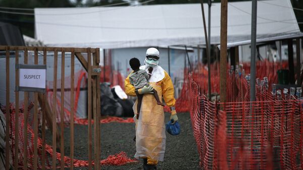طبيب يحمل طفلا يشتبه بإصابته بفيروس إيبولا - سبوتنيك عربي