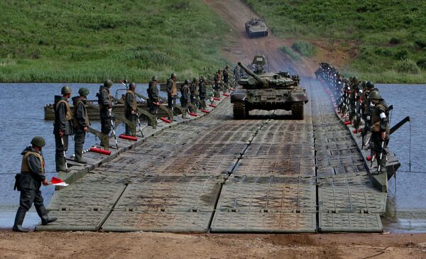 الدبابات والمدرعات تعبر النهر على جسر عائم شيدته وحدات الهندسة التابعة للجيش الروسي الخامس أثناء تدريباتها على عبور الموانع المائية - سبوتنيك عربي