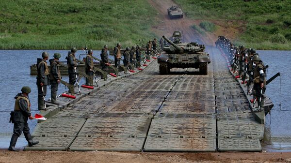 الدبابات والمدرعات تعبر النهر على جسر عائم شيدته وحدات الهندسة التابعة للجيش الروسي الخامس أثناء تدريباتها على عبور الموانع المائية - سبوتنيك عربي