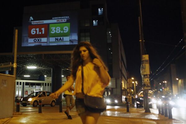 فتاة تسير فى شوارع أثينا وفى الخلفية نتيجة الاستفتاء التى تظهر ارتفاع مؤشر الرفض - سبوتنيك عربي
