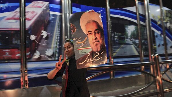 فتاة تحمل صورة الرئيس الإيراني حسن روحاني احتفالاً بالاتفاق النووي - سبوتنيك عربي