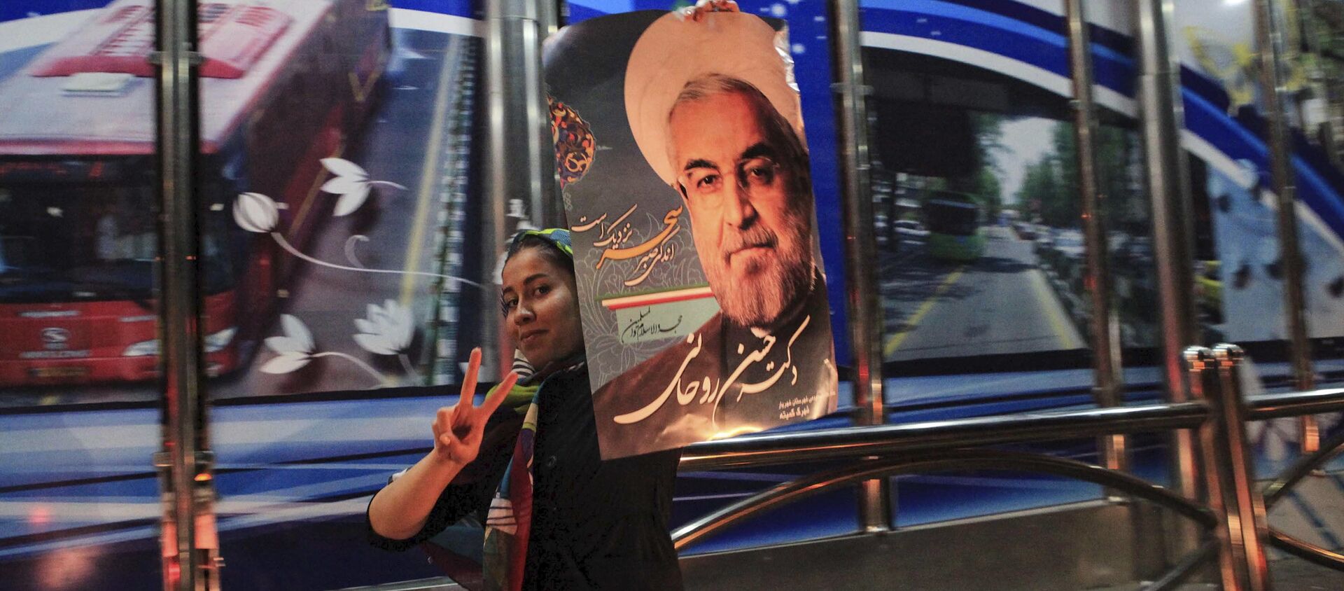 فتاة تحمل صورة الرئيس الإيراني حسن روحاني احتفالاً بالاتفاق النووي - سبوتنيك عربي, 1920, 30.03.2021