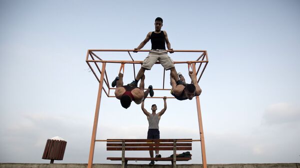 عدد من الشباب الفلسطيني يمارس تمارين رياضية في أحد الشوارع على ساحل البحر في غزة - سبوتنيك عربي