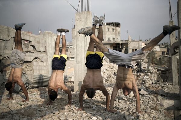 مجموعة من الشباب الفلسطيني تمارس رياضة الشوارع على أنقاض مدينة غزة - سبوتنيك عربي