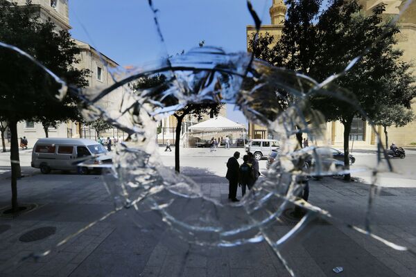 ثقب في واجهة محل تجاري، من آثار اشتباكات ليلية بين المتظاهرين والشرطة في لبنان - سبوتنيك عربي