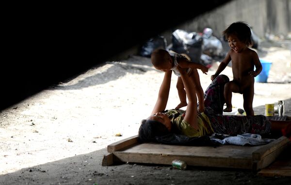 سعادة الفقراء: أم مع أطفالها تحت تحت أحد الجسور في مانيلا (عاصمة الفلبين) - سبوتنيك عربي