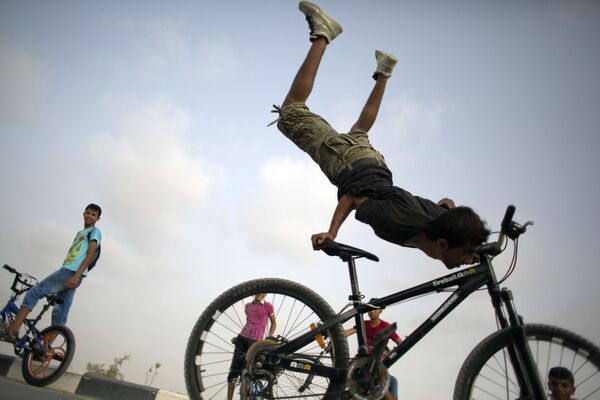 شاب فلسطيني أثناء قيامه بحركة بهلوانية باستخدام دراجته - سبوتنيك عربي