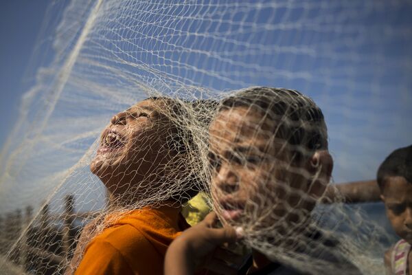 أطفال قطاع غزة يلعبون بشباك صيد السمك - سبوتنيك عربي