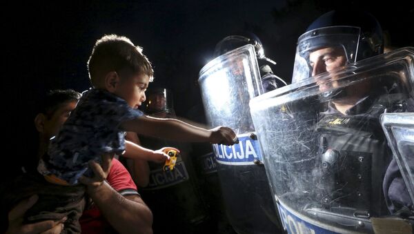 طفل يمد يده إلى درع الشرطي في كرواتيا - سبوتنيك عربي