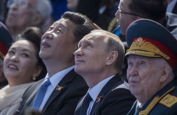 الرئيس الروسي فلاديمير بوتين والرئيس الصيني شي جين بينغ بصحبة عقيلته أثناء العرض العسكري بمناسبة الذكرى الـ70 لعيد النصر في الحرب العالمية الثانية - سبوتنيك عربي