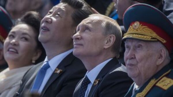 الرئيس الروسي فلاديمير بوتين والرئيس الصيني شي جين بينغ بصحبة عقيلته أثناء العرض العسكري بمناسبة الذكرى الـ70 لعيد النصر في الحرب العالمية الثانية - سبوتنيك عربي