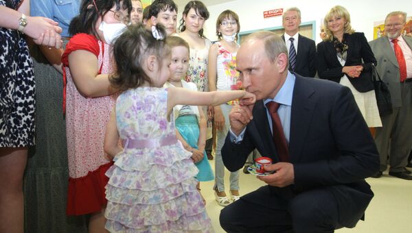 الرئيس بوتين يقبل يد طفلة صغيرة قامت بتقديم هدية له أثناء زيارته إلى مركز أمراض الدم، والمناعة والأورام - سبوتنيك عربي