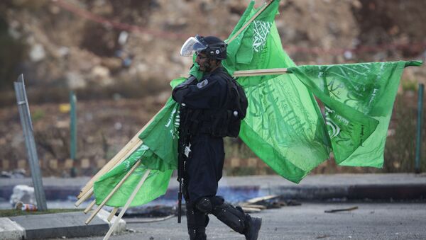 ضابط اسرائيلي يجمع اعلام حماس - سبوتنيك عربي