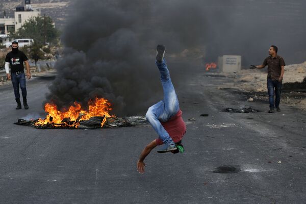 شاب فلسطيني يستفز ويسخر من جنود حرس الحدود الاحتلال الإسرائيلي بالقرب من مستوطنة بيت-إيل في شمال شرق مدينة البيرة. - سبوتنيك عربي