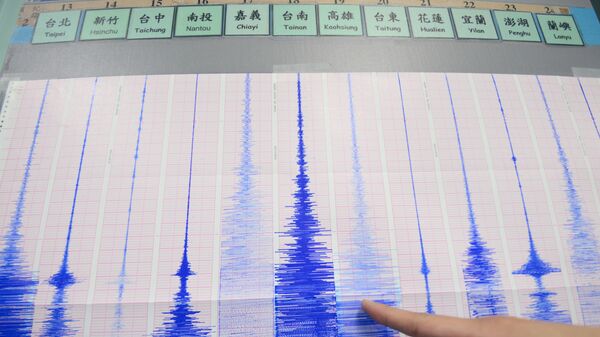 A staff member of the Seismology Center points to a chart showing the earthquake activity detected by the central Weather Bureau in Taipei on April 20, 2015 - سبوتنيك عربي