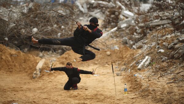 شاب فلسطيني يقفز حاملاً سيفه، مقدماً بذلك مهارات النينجا، من أمام المباني المدمرة إثر الحرب الأخيرة 2014، شمال قطاع غزة، 29 يناير/ كانون الثاني 2016. - سبوتنيك عربي