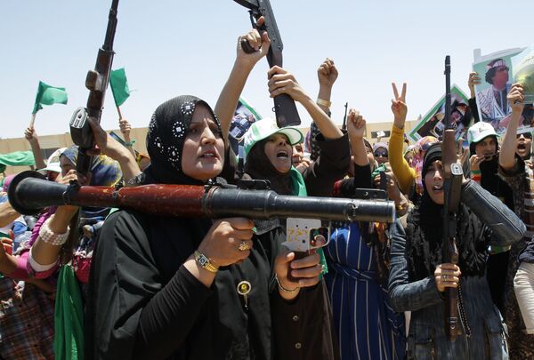 المواليات للقائد الليبي معمر القذافي تحملن السلاح خلال المواجهات الحربية في بلدة بن جواد في ليبيا - سبوتنيك عربي
