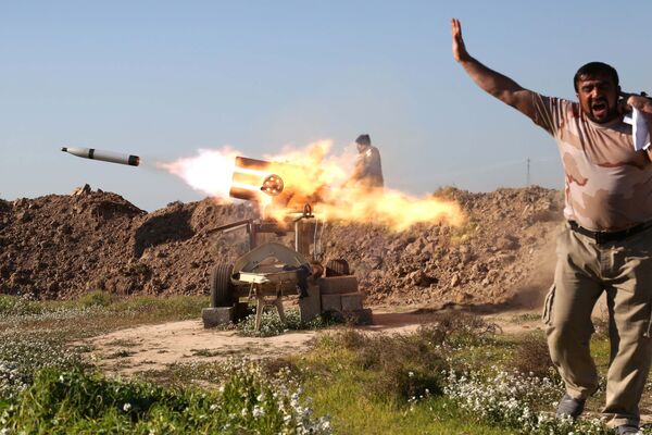 محارب عراقي يغلق آذانه عند إطلاق الصواريخ في شمال غرب العراق، 16 فبراير/ شباط 2016. - سبوتنيك عربي