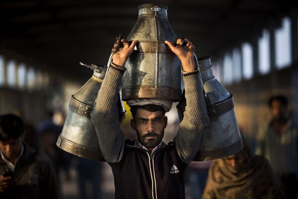 رجل هندي يحمل جرات حليب على محطة قطارغازي آباد في الهند، 24 فبراير/ شباط 2016. - سبوتنيك عربي