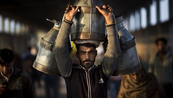 رجل هندي يحمل جراتحليب على محطة قطارغازي آباد في الهند، 24 فبراير/ شباط 2016. - سبوتنيك عربي